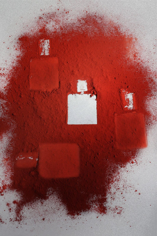 Luxury niche Eau De Parfum bottles surrounded by vibrant red saffron powder symbolizing spicy oriental fragrance composition