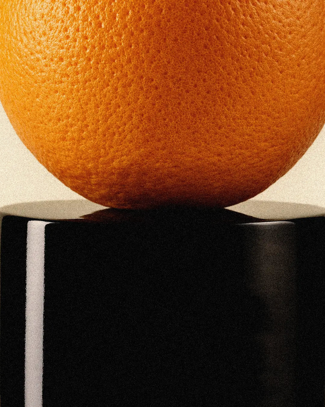 Close-up of an orange on a black and white geometric background